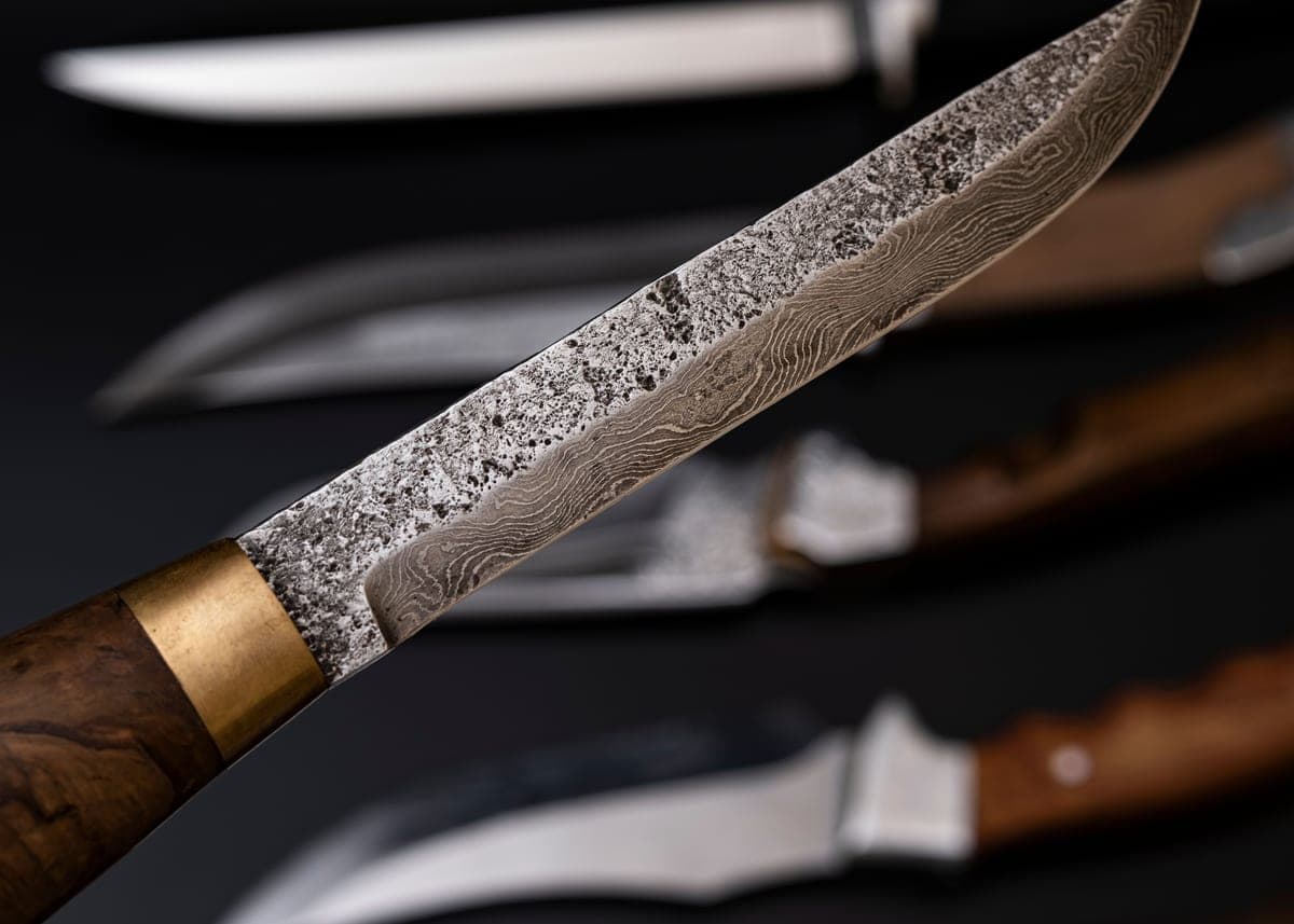 Forged knife blades with wooden handles on a dark background